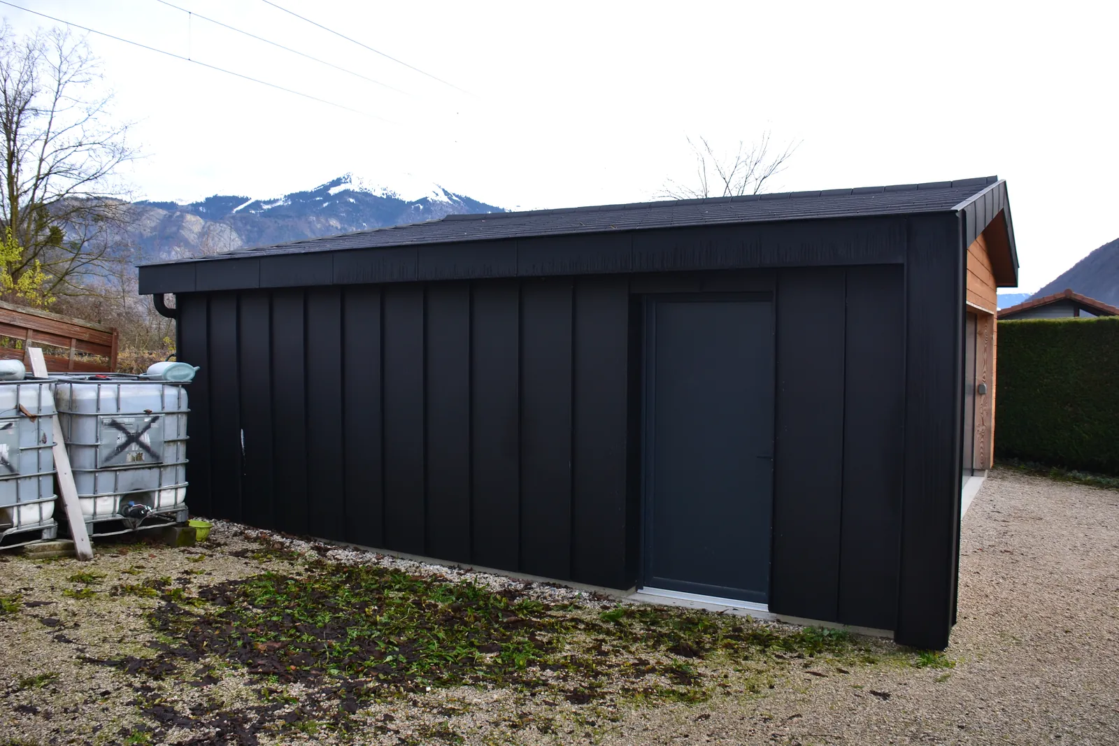 Construction bois avec bardage sombre en fond de vallée